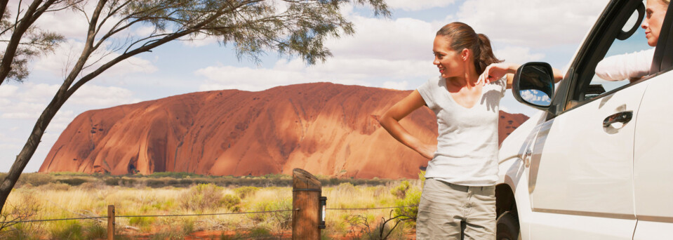 Frauen mit Mietwagen vor Ayers Rock